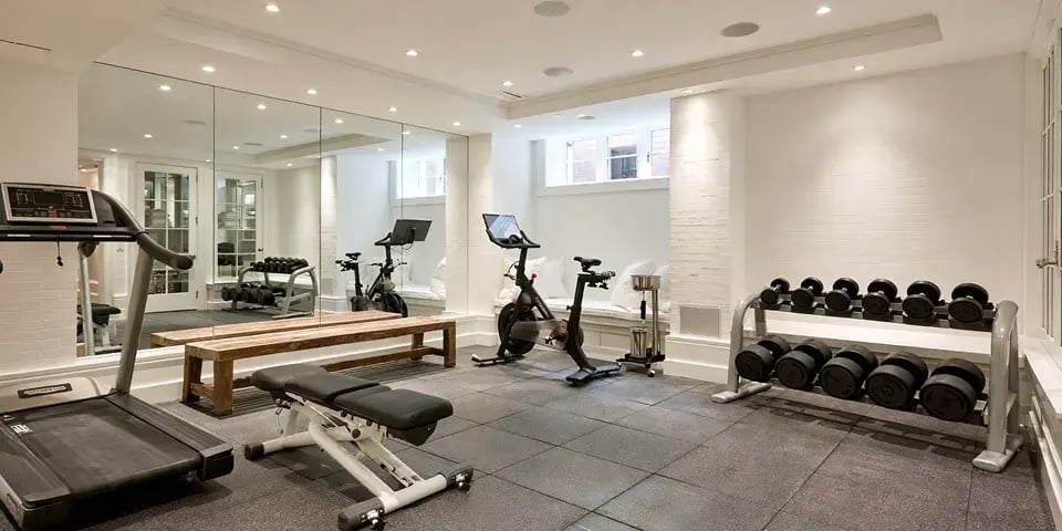 bizzywebai_Bright_clean_finished_basement_home_gym_rubber_floor_838224e5-70c4-418c-b369-9033c6f1a31d 1